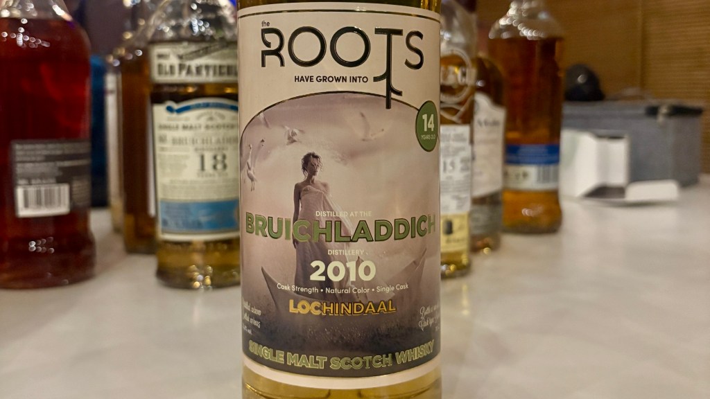 A close-up of a bottle of Bruichladdich single malt Scotch whisky, labeled as 14 years old and distilled in 2010. The bottle features the text 'the ROOTS HAVE GROWN INTO' and 'Lochindaal' on the label, with a beige background and a depiction of a woman and birds.
